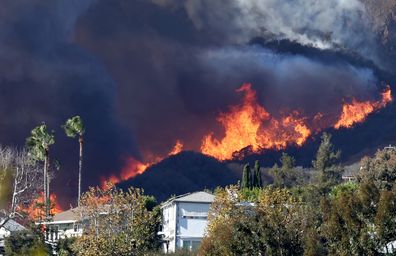 PACIFIC PALISADES, CALIFORNIA - JANUARY 07: The Palisades Fire burns near homes amid a powerful windstorm on January 7, 2025 in Pacific Palisades, California. The fast-moving wildfire is threatening homes in the coastal neighborhood amid intense Santa Ana Winds and dry conditions in Southern California. (Photo by Mario Tama/Getty Images)